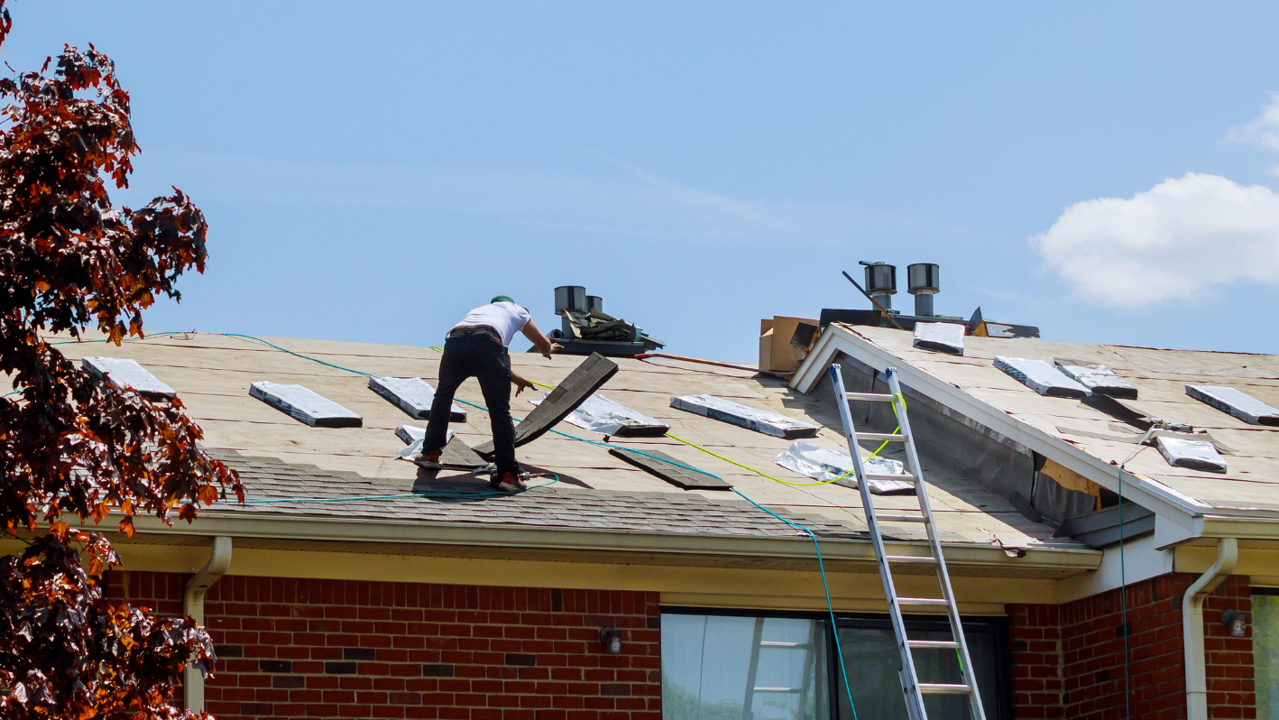 A man working on a roof with a ladder