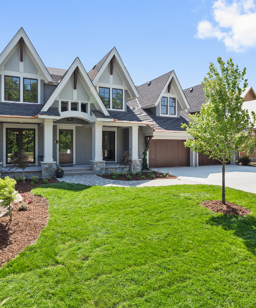 A large house with a lot of windows and lots of grass